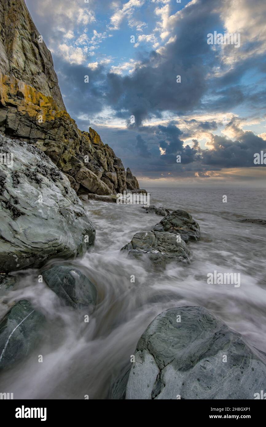La penisola di Howth Head in giornata soleggiata e nuvolosa, esposizione a lungo, Dublino County, Seashore di scogliere, baie e rocce paesaggio, Irlanda Foto Stock
