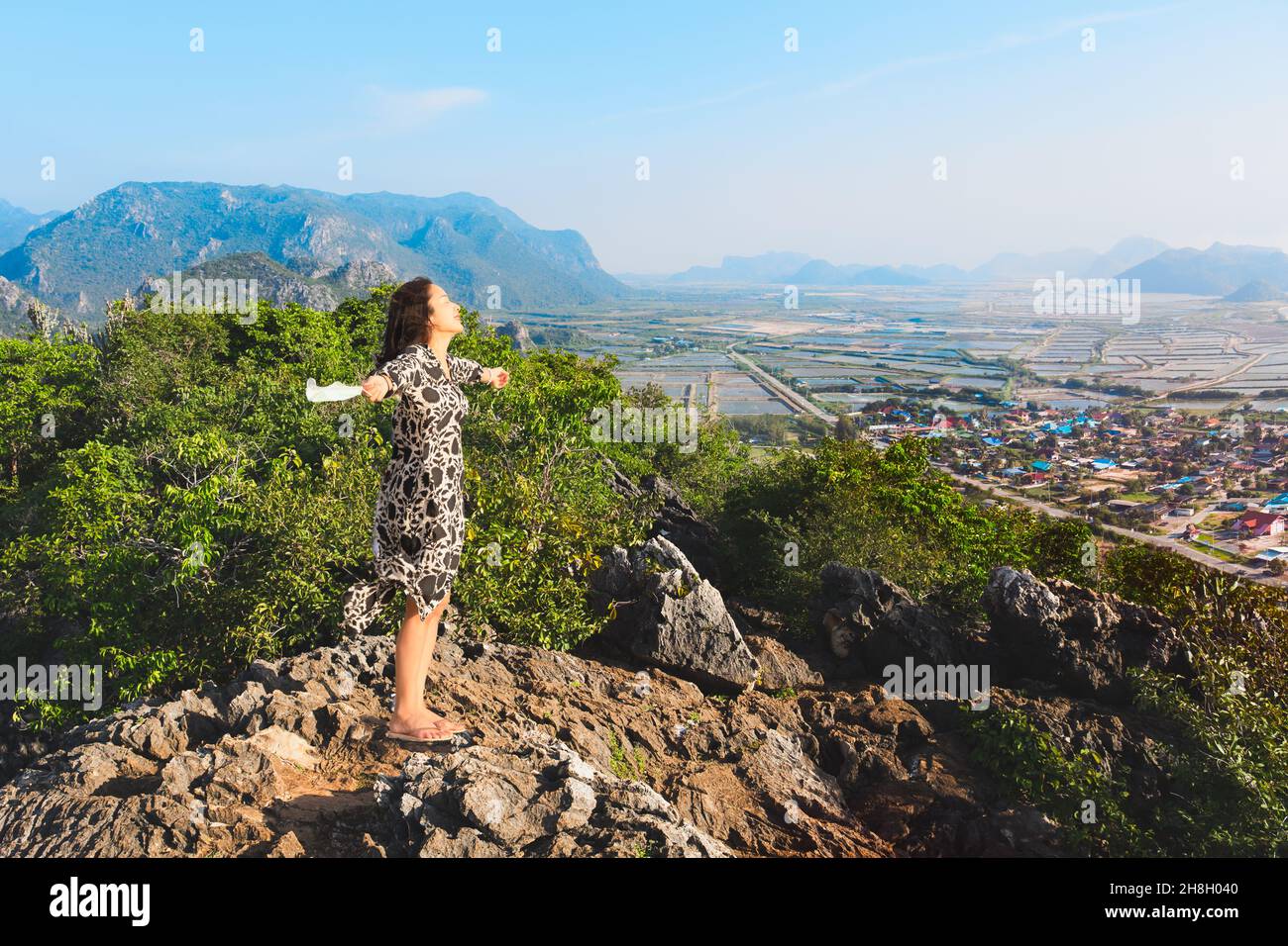 Donna felice rimuovere maschera in piedi sulla cima alito di montagna di aria fresca. Foto Stock