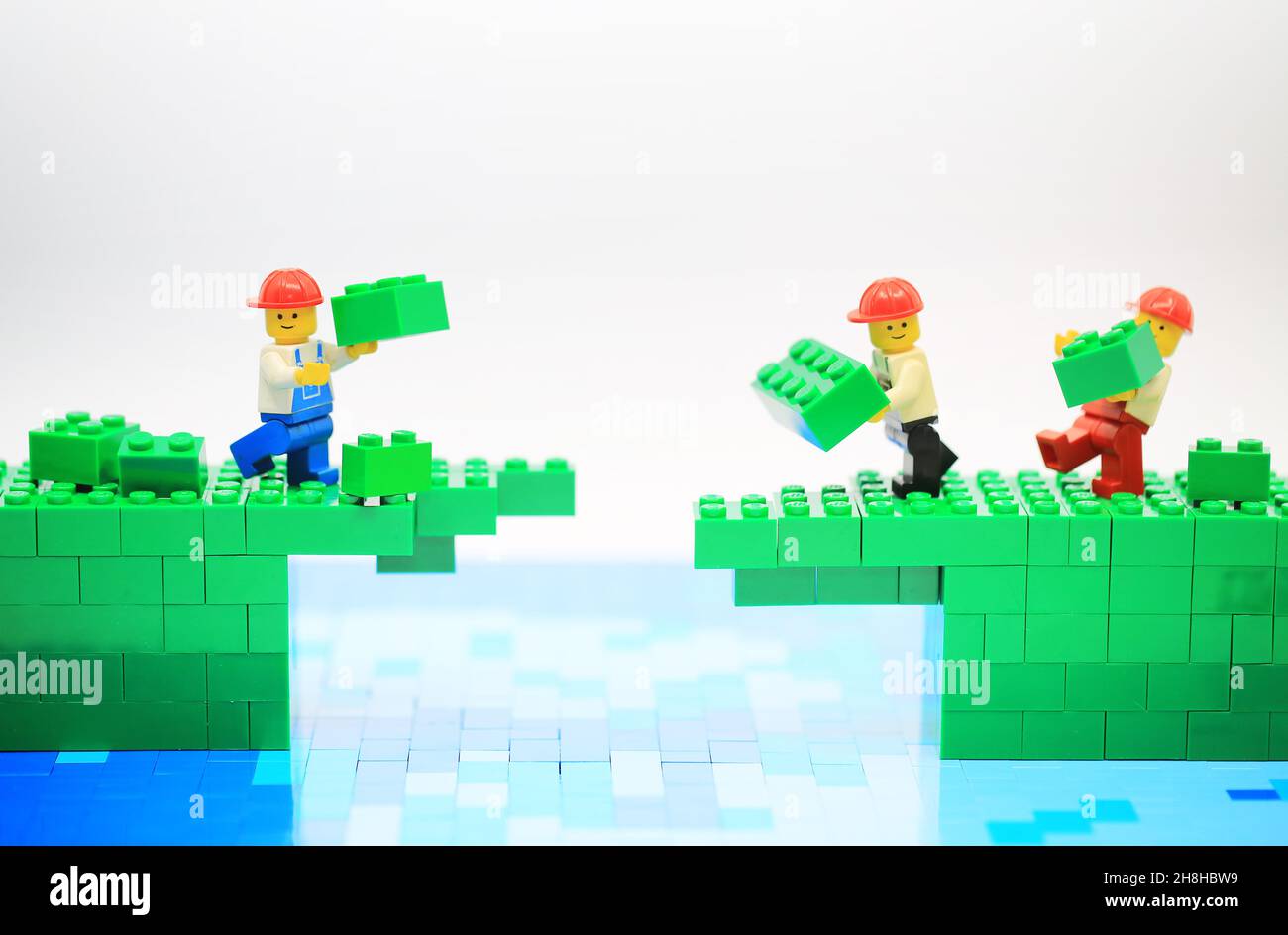 lego man costruisce il ponte e supera il divario Foto Stock