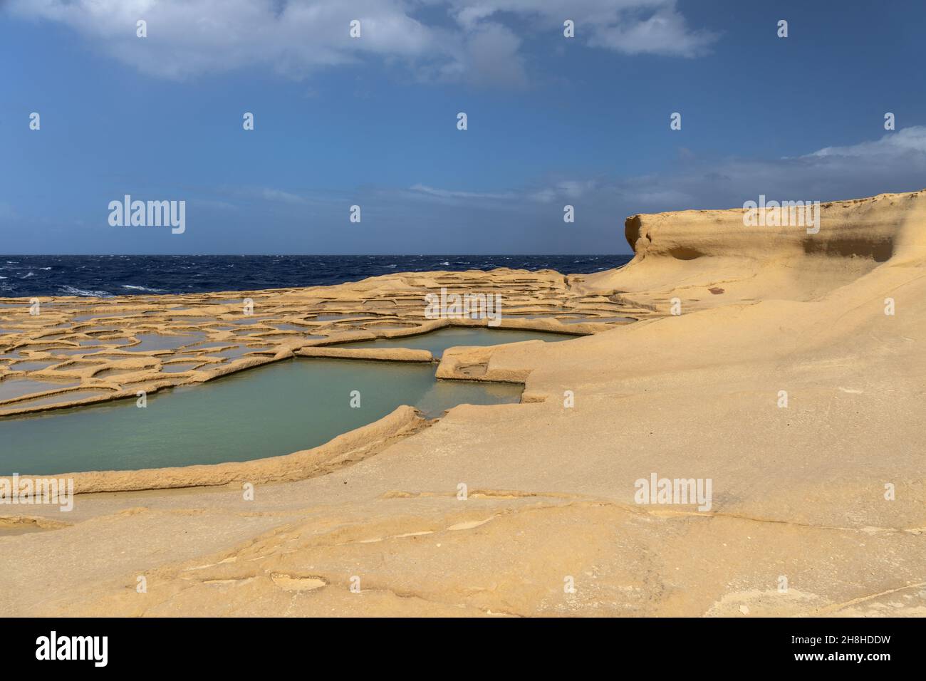 Le saline di Xwejni a Gozo, Malta. Un pittoresco paesaggio di Saline utilizzato per la produzione tradizionale di sale marino e il Mar Mediterraneo Foto Stock