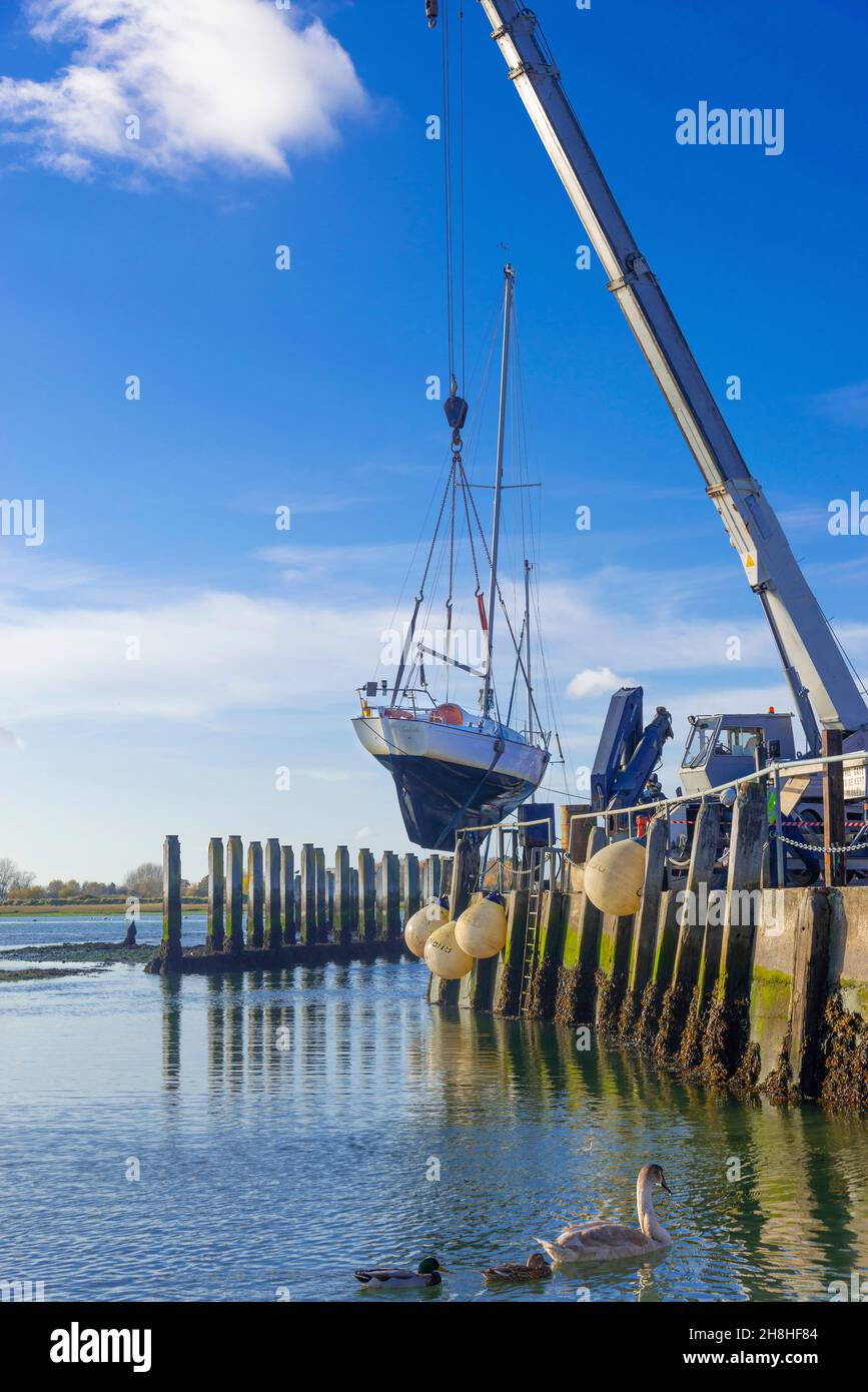 Craned out yacht in imbracature (Contessa 26) lo scafo è stato lavato a pressione per rimuovere le erbacce a Bosham Quay, Chichester Harbour, West Sussex, Inghilterra, Regno Unito Foto Stock