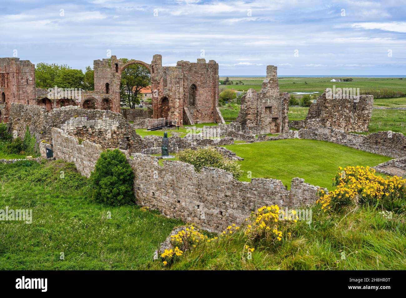 Vista delle rovine del Priorato di Lindisfarne dal Heugh sull'Isola Sacra sulla costa del Northumberland d'Inghilterra, Regno Unito Foto Stock