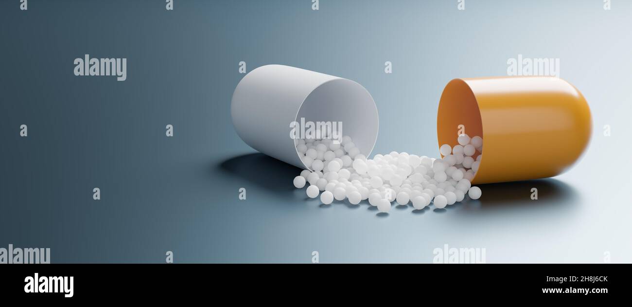 Una capsula di pillola aperta che spillano il principio attivo Foto Stock