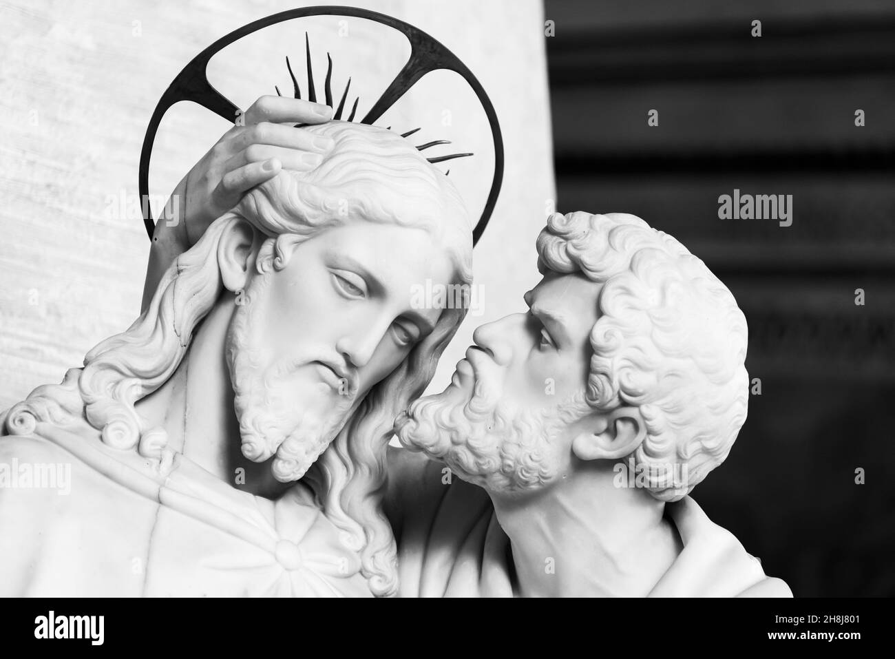 Foto in bianco e nero che mostra statue in primo piano raffiguranti Giuda che bacia Gesù sulla guancia Foto Stock