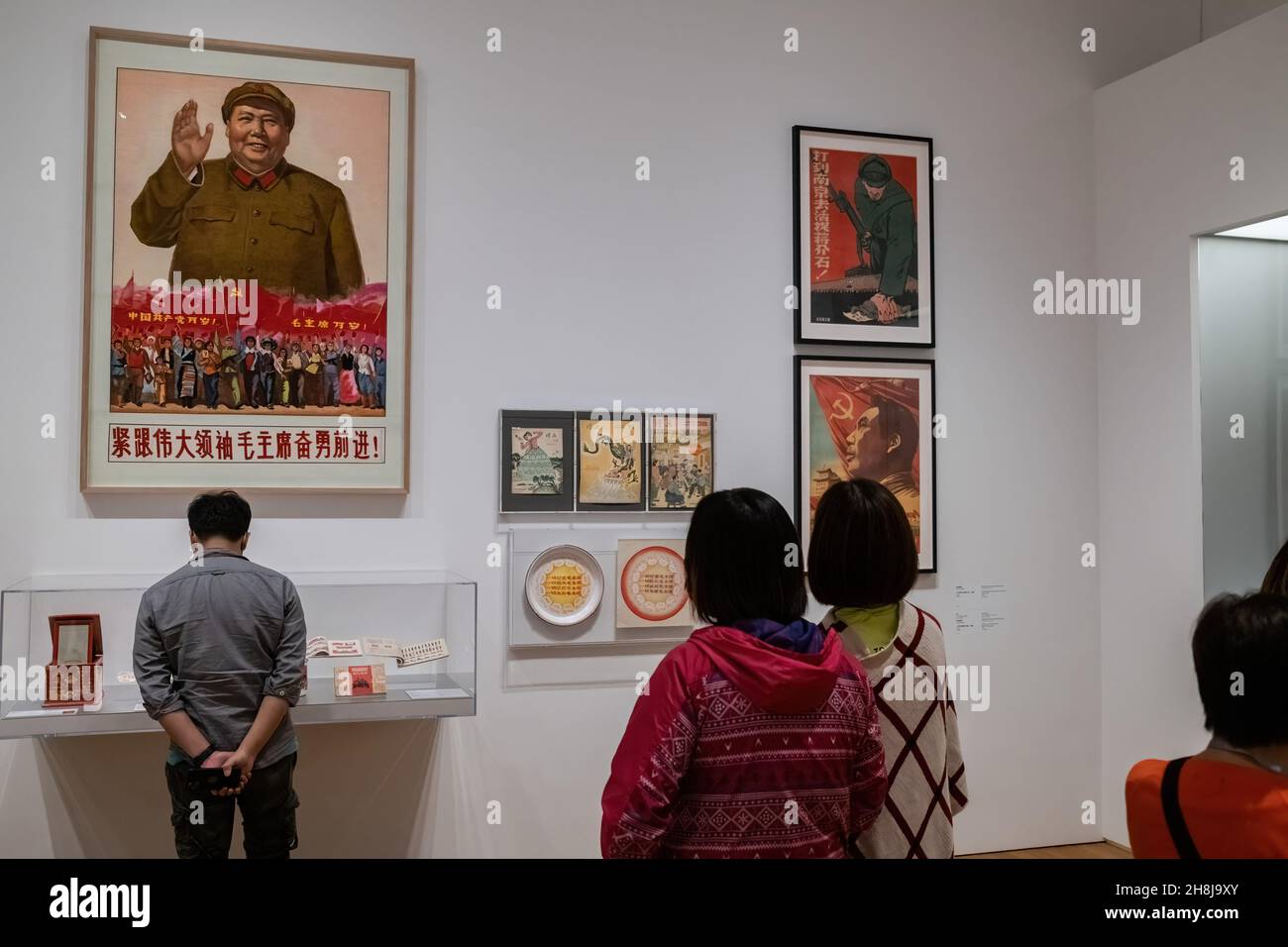 Hong Kong, Cina. 30 Nov 2021. I visitatori osservano un'opera d'arte "Tapestry PosteróMarch on with Chairman Mao" di artisti sconosciuti nel museo M di recente apertura. Il museo M, uno dei più grandi musei di cultura visiva moderna e contemporanea al mondo, si è aperto in mezzo a controversie sulla censura politica. (Foto di Isaac Wong/SOPA Images/Sipa USA) Credit: Sipa USA/Alamy Live News Foto Stock