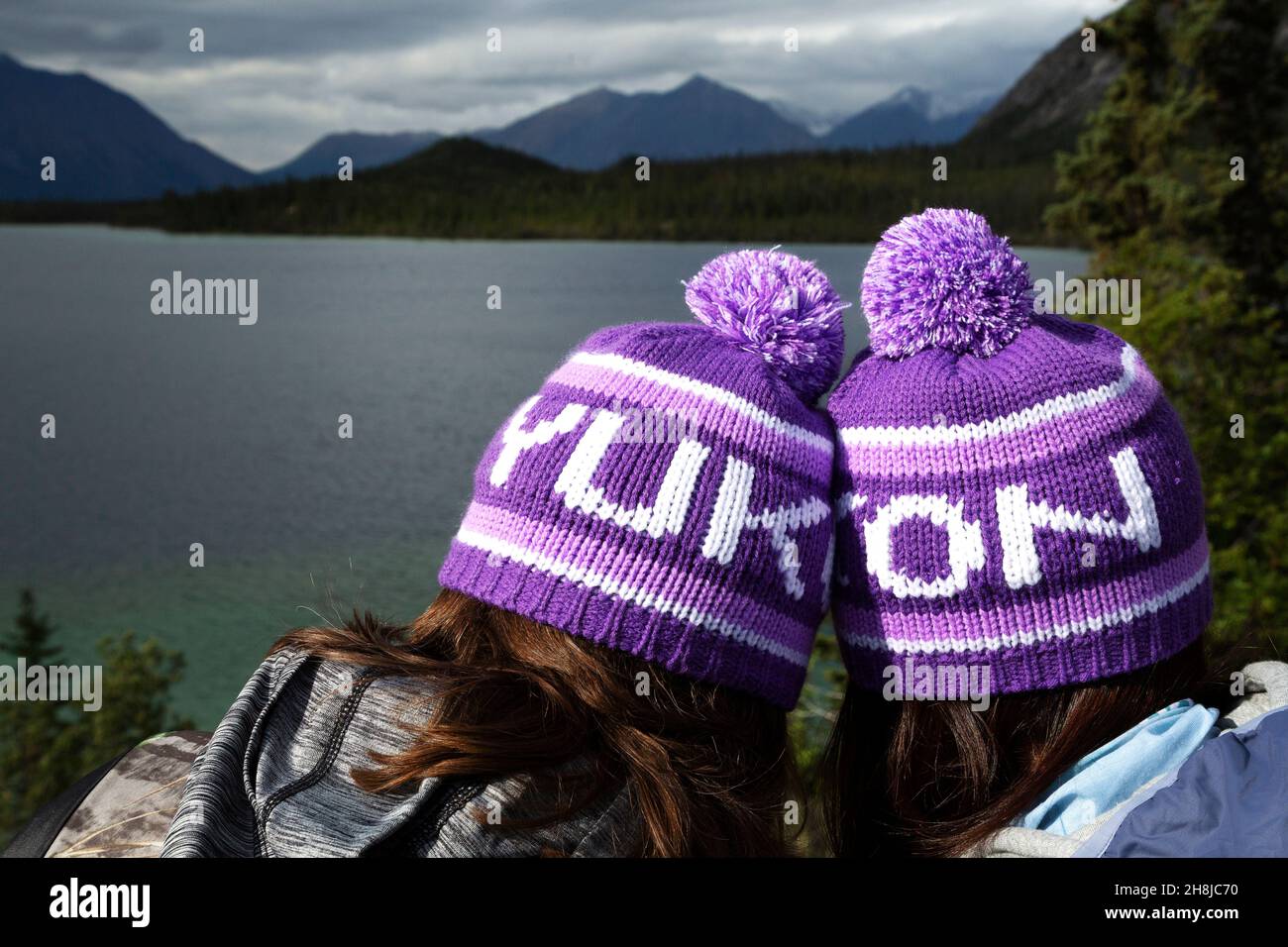 Persone che indossano cappelli di bobble Yukon, noto come toquesin the Yukon, Canada. Si affacciano su uno dei laghi del territorio. Foto Stock