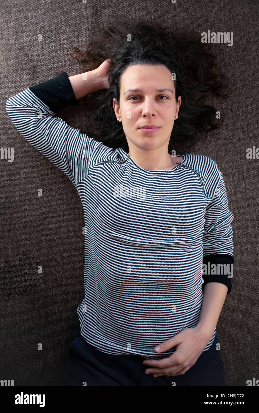 Concetto di salute mentale - giovane donna che si trova sul pavimento nel pensiero Foto Stock