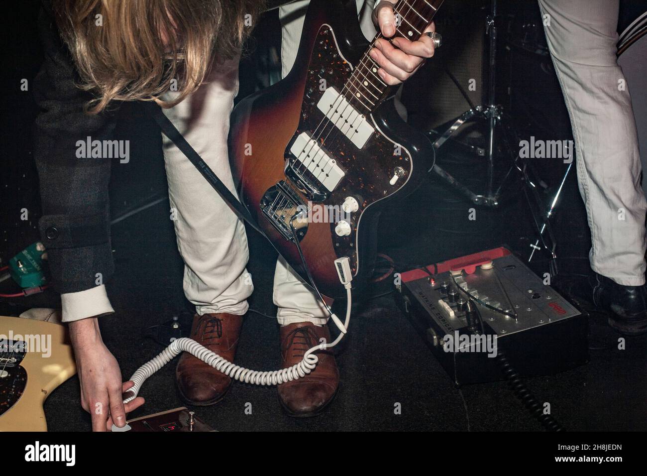 uomo che scollega la chitarra elettrica in uno studio di prove. Foto Stock