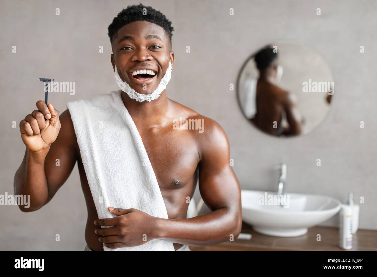 Il Razor di sicurezza dell'uomo nero eccitato in stanza da bagno Foto Stock