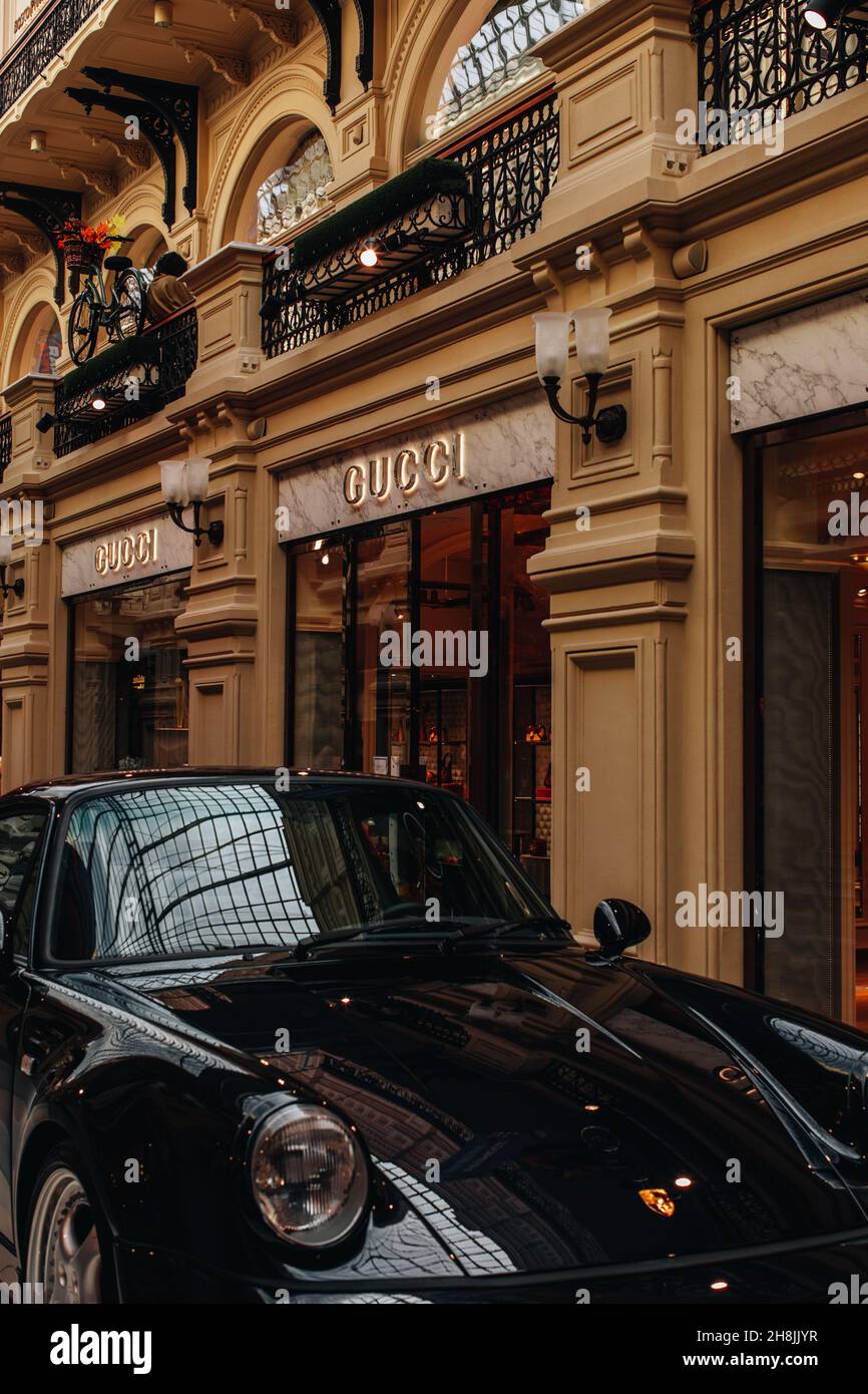 Auto di lusso nera lucida in piedi vicino ad un negozio Gucci. Gucci è un  marchio italiano di moda e pelletteria fondato da Guccio Gucci a Firenze  nel 1921 Foto stock - Alamy