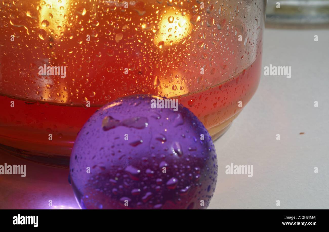 Candela ambra dietro una palla viola. Foto Stock