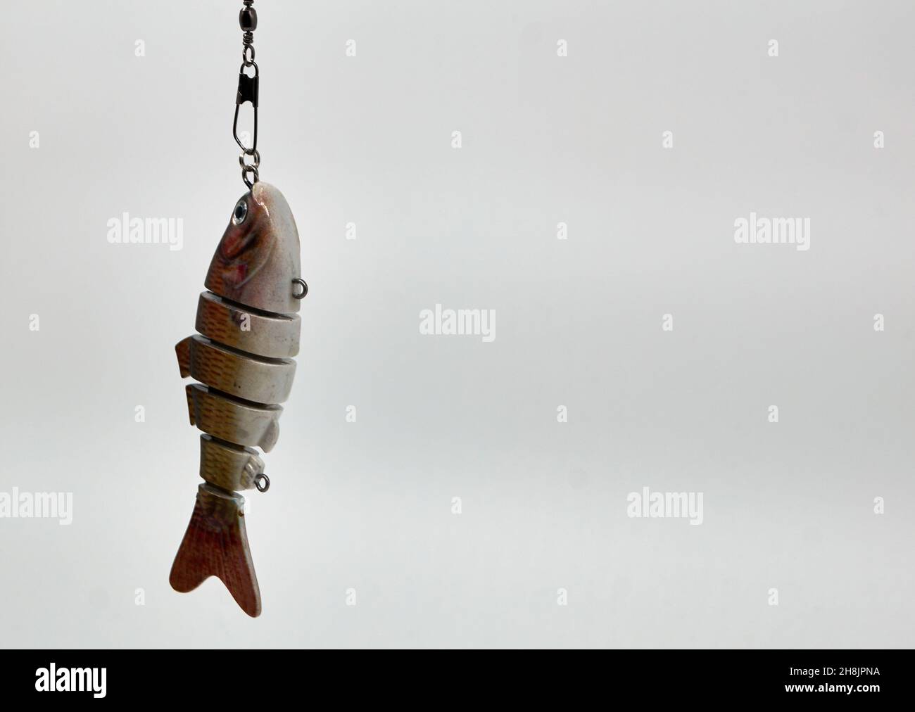 Un pesce artificiale, utilizzato come esca dai pescatori su sfondo bianco. Con spazio per il testo. Foto Stock