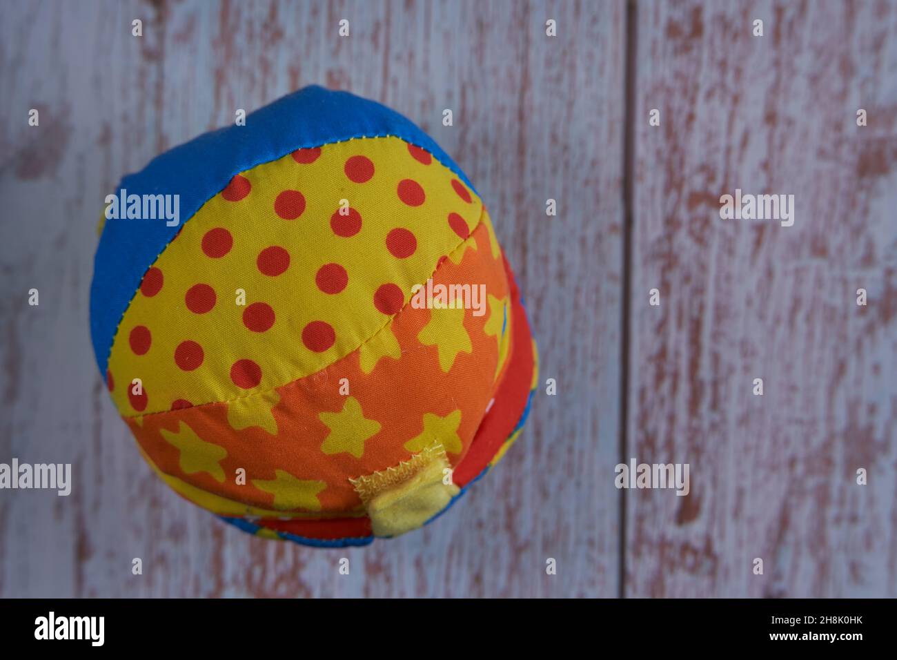 baby giocattolo in cotone a forma di pallina sovrapposta a un tavolo in legno Foto Stock