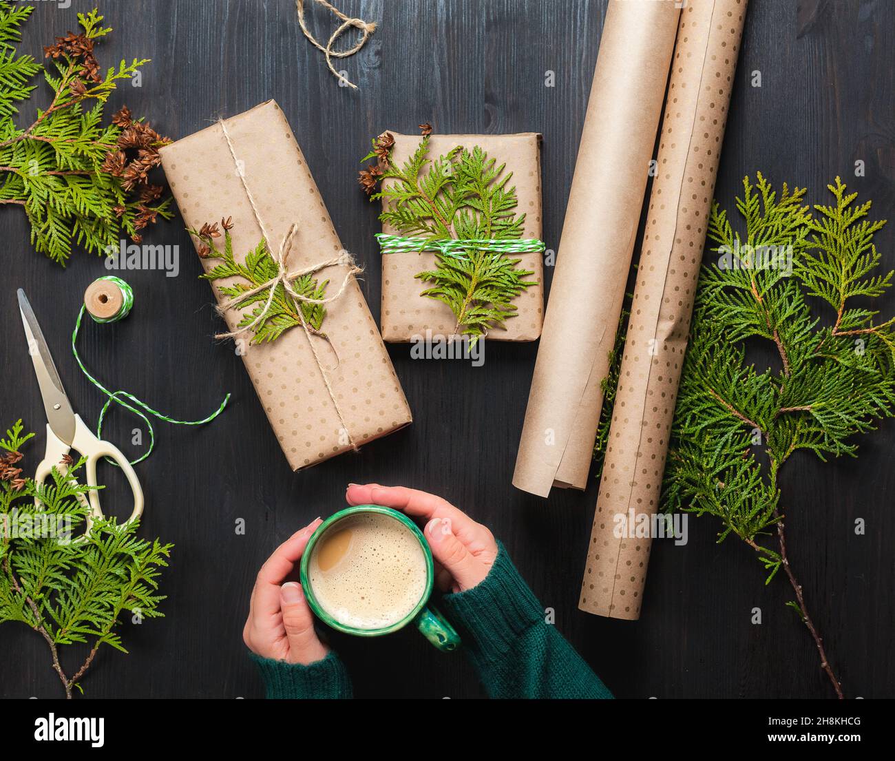 Scatole regalo natalizie avvolte in carta artigianale con rami thuja Foto Stock