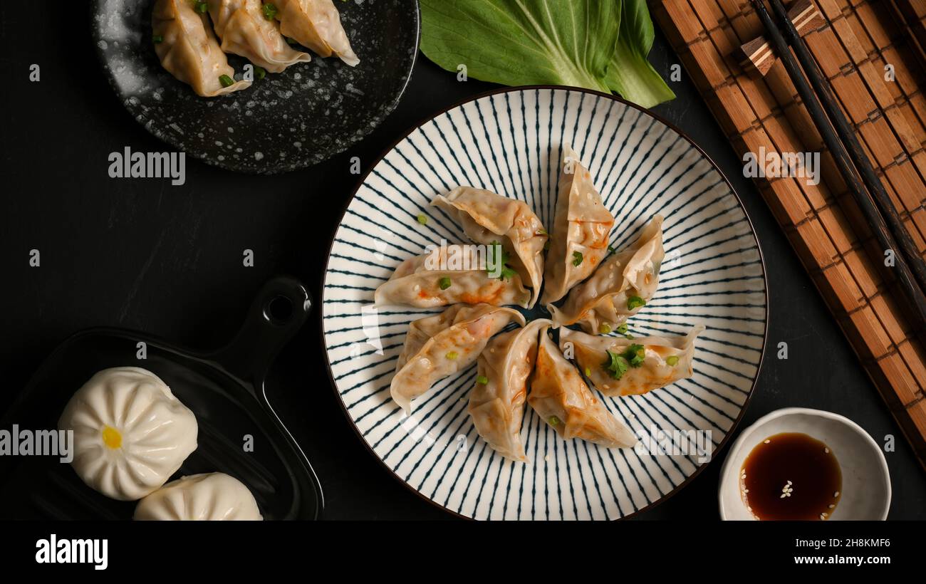Gnocchi giapponesi al vapore e focaccine di maiale su un piatto. Cucina asiatica. Gnocchi gyoza asiatici. Vista dall'alto Foto Stock