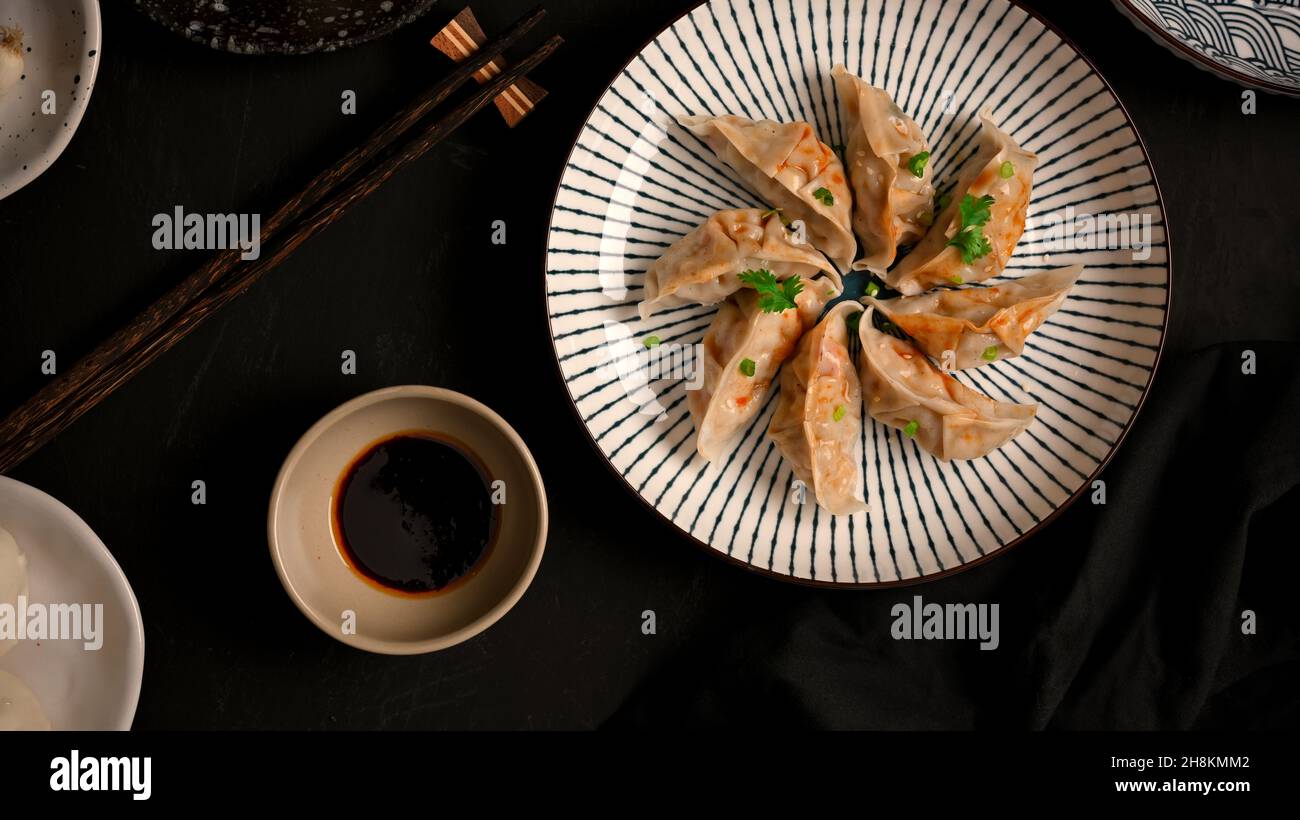 Gnocchi di gyoza giapponese al vapore su un piatto con salsa di soia. Contorno asiatico. Vista dall'alto Foto Stock