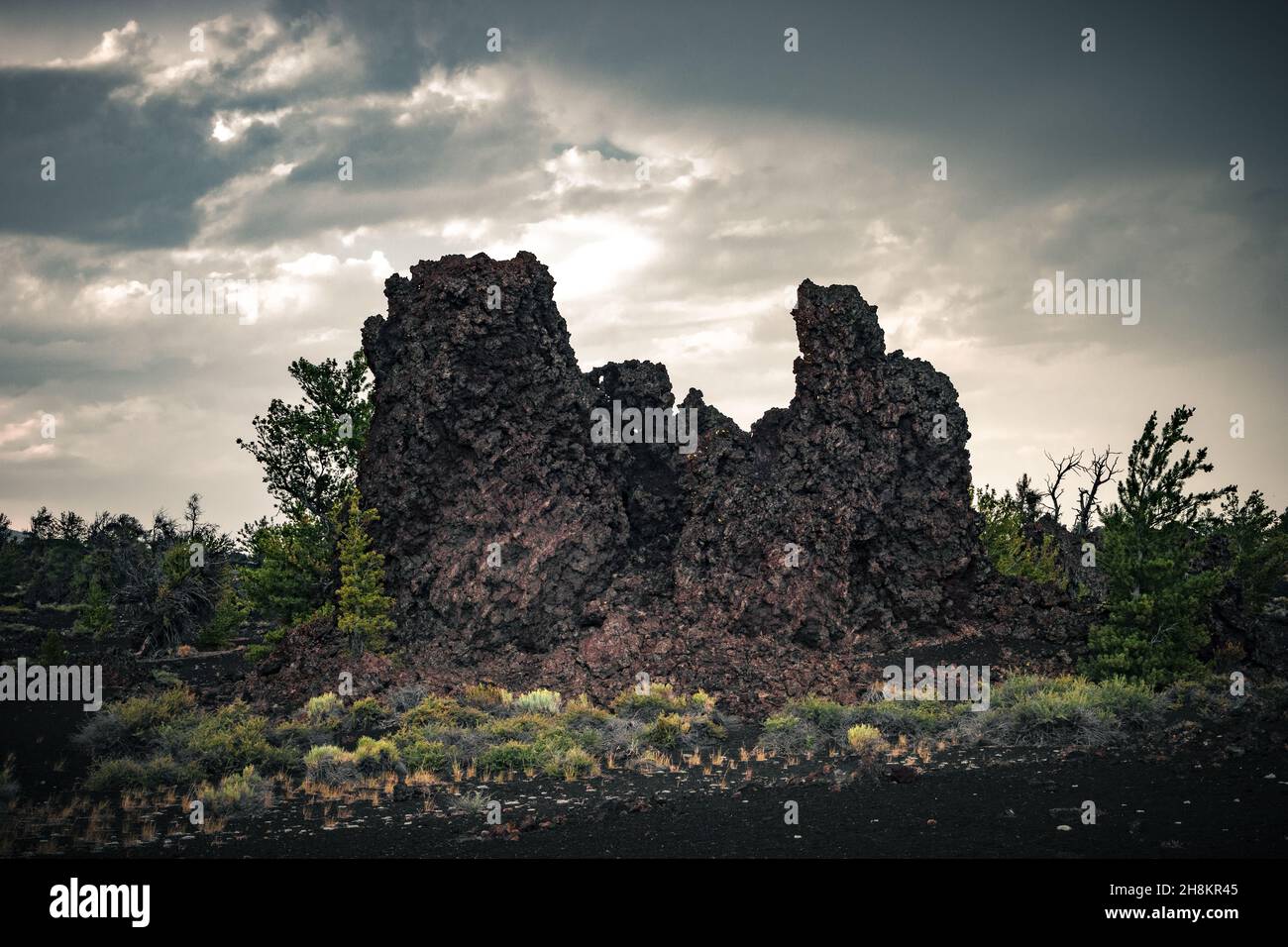 Vista dei campi ricoperti di lava e piante all'orizzonte, colline laviche, paesaggio vulcanico al Craters of the Moon National Monument & Preserve Foto Stock