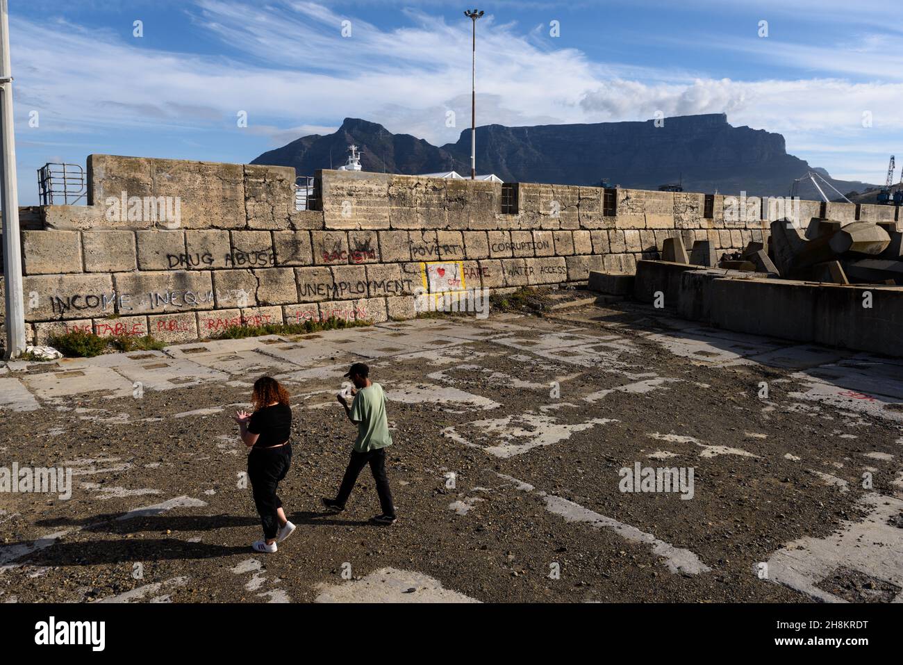 Graffiti sul muro del porto di Città del Capo è una lista di controllo per le sfide del Sud Africa che minacciano di far deragliare i progressi per la società post-apartheid Foto Stock