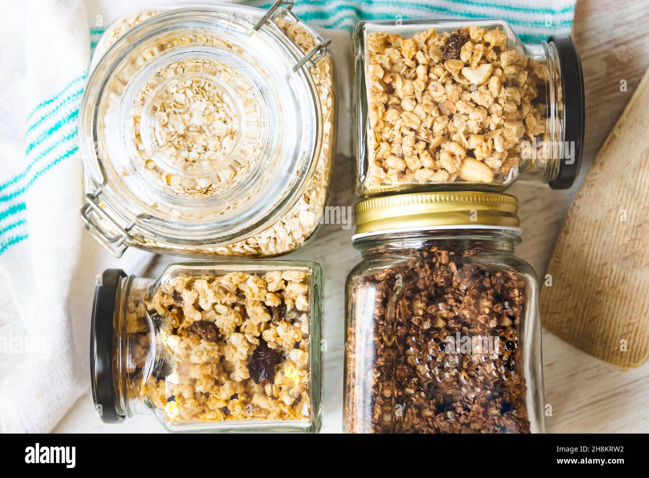 Vista dall'alto di vasetti pieni di avena e vari granoli croccanti - frutta secca, noci e cioccolato. Concetto di mangiare sano. Foto Stock