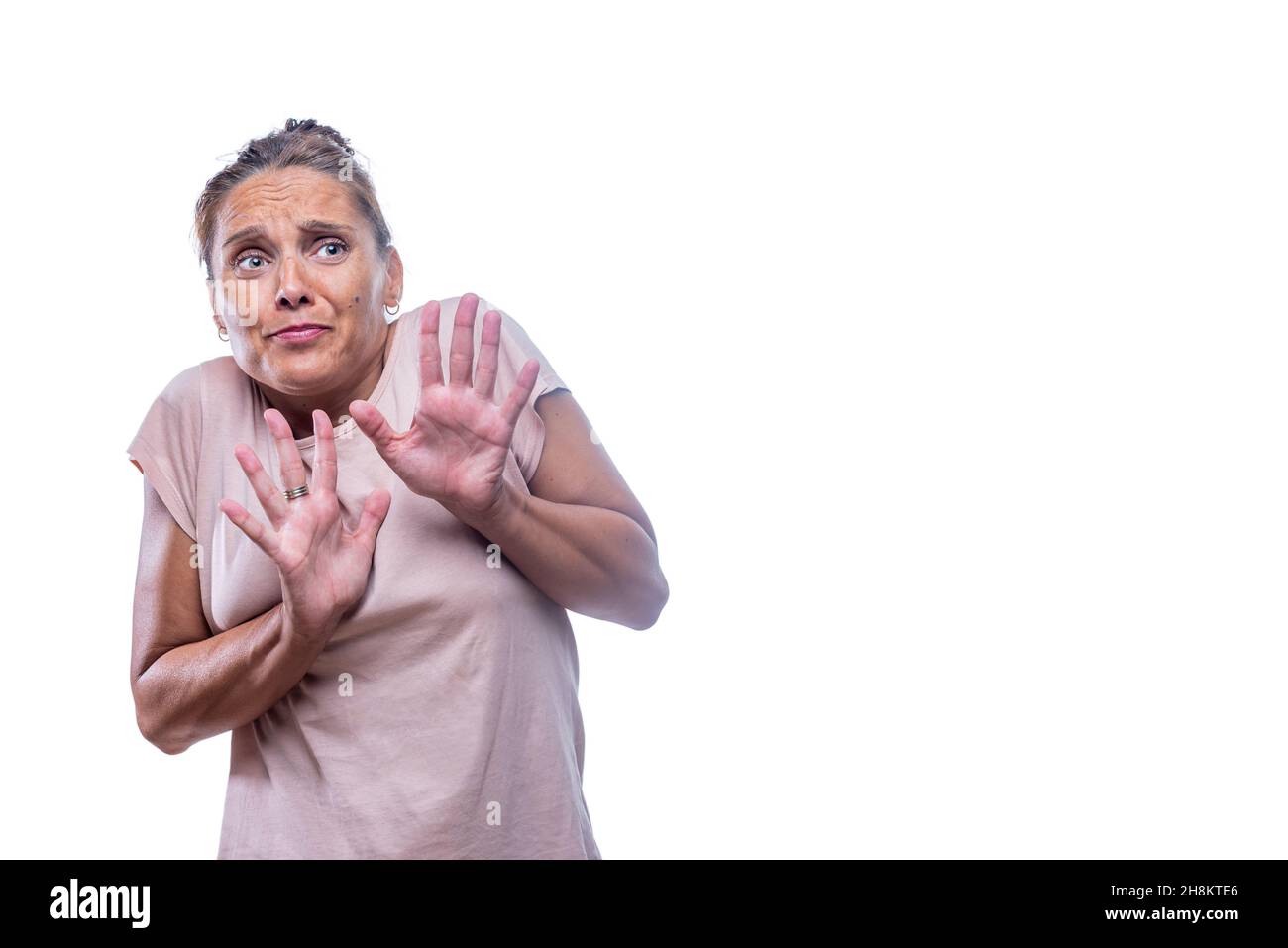 Una donna adulta spaventata su sfondo bianco Foto Stock