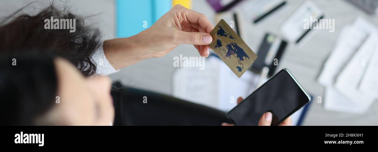 Donna tiene in mano carta di credito plastica e smartphone Foto Stock