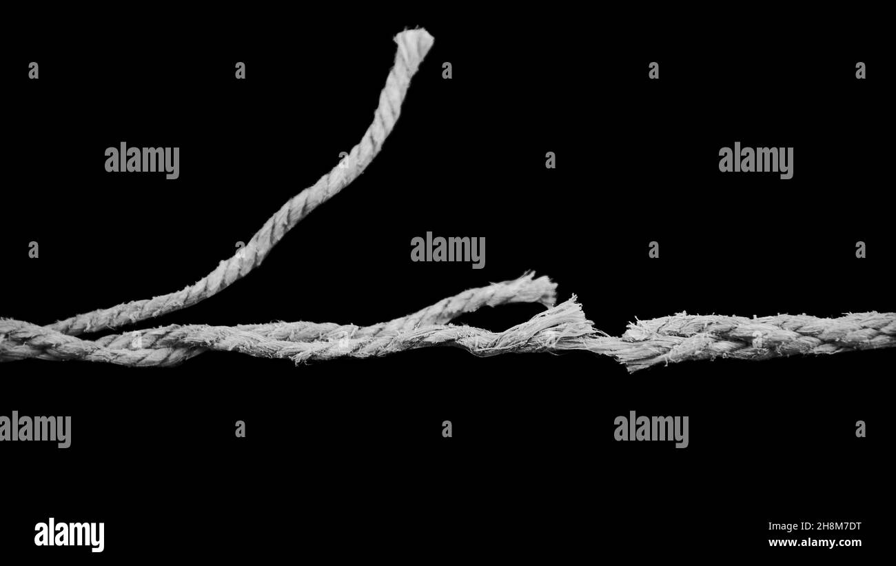 Processo di rottura della fune isolato su sfondo nero, concetto di liberazione. Foto Stock