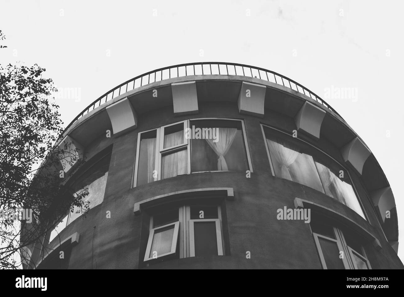 Fondo su cemento nero bianco moderno Sky torre edificio medievale fortezza stile castello rotondo tetto sporgere mattoni metallo ringhiera grande finestra inusuale Foto Stock