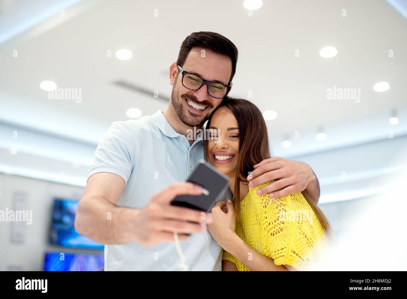 Bella coppia shopping. Alla ricerca di un nuovo tablet nel negozio tecnologico. Foto Stock