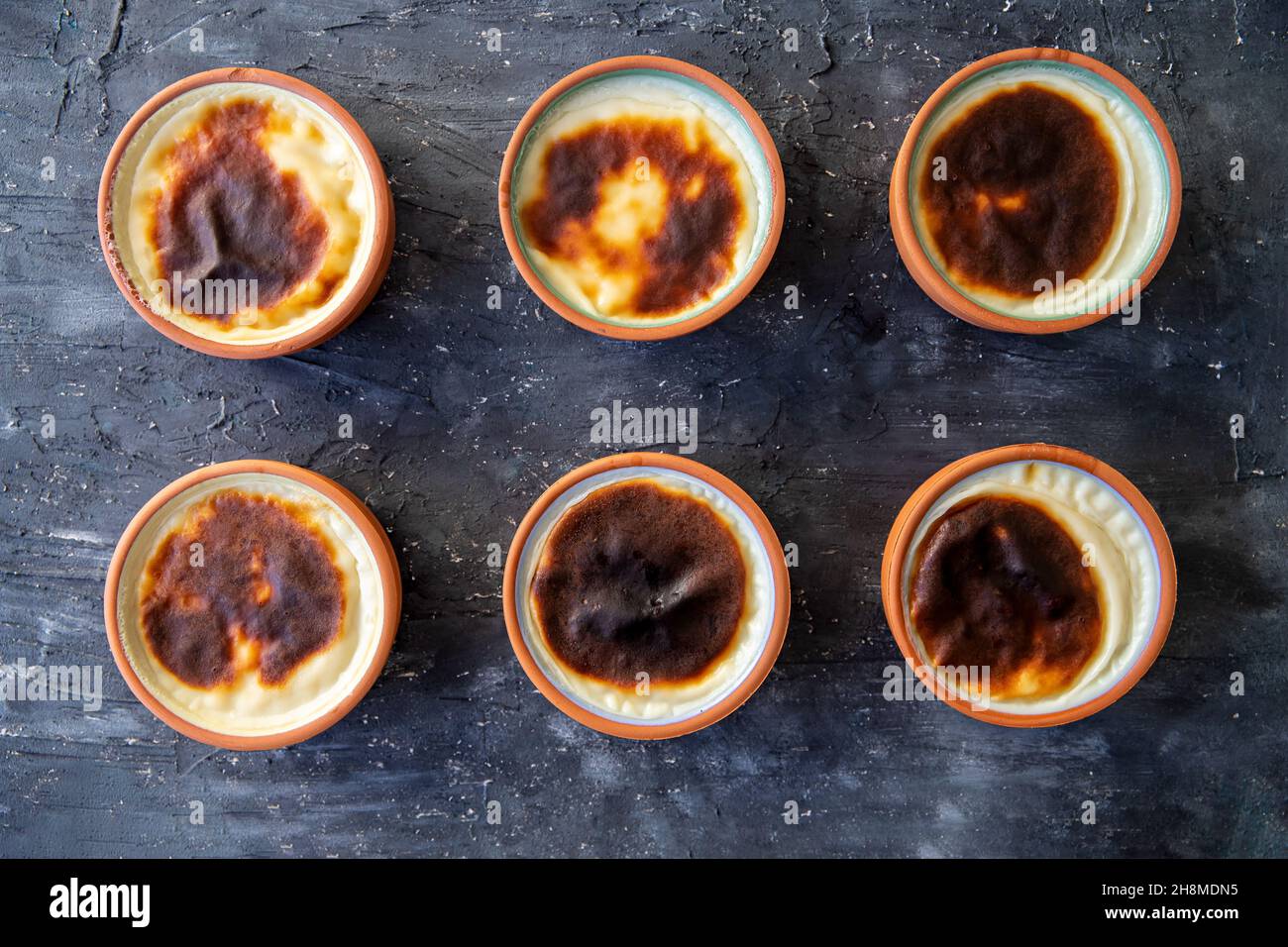 Dessert al budino di riso cotto in una pentola di argilla nel forno. Pronto per essere servito su un tabellone nero Foto Stock