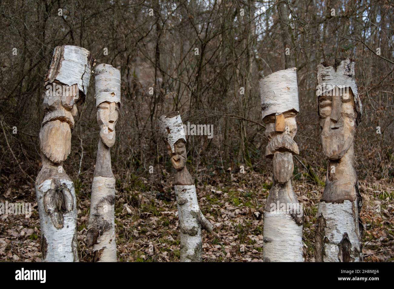 Divertenti facce intagliate in legno di betulla Foto Stock