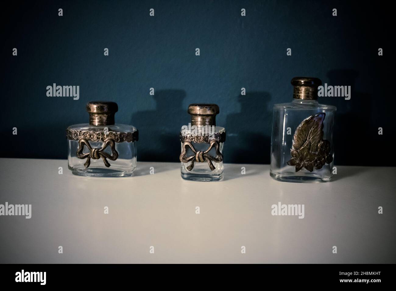 alcune bottiglie, fiale su un tavolo bianco in una stanza con sfondo blu. interni design. Foto Stock