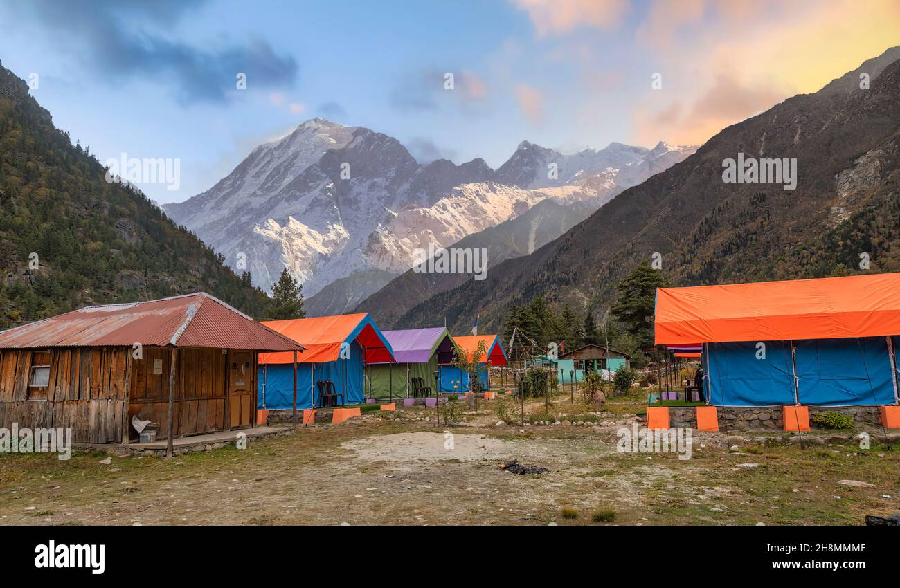Tende da campeggio per gli amanti dell'avventura e gli escursionisti a Rakchham Himachal Pradesh, India con paesaggio panoramico di montagna Himalaya al tramonto Foto Stock