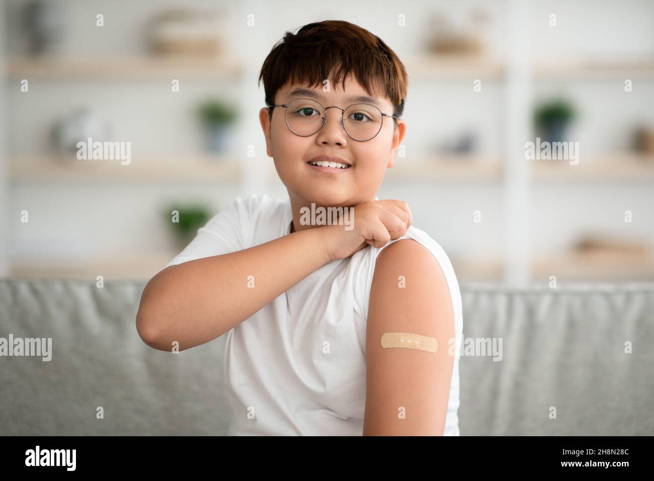 Primo piano di ragazzo asiatico felice è stato vaccinato contro il coronavirus Foto Stock