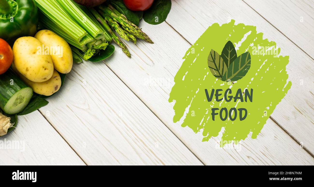 Vista ad angolo alto del cibo vegano simbolo in verde da verdure fresche su tavola di legno bianco Foto Stock