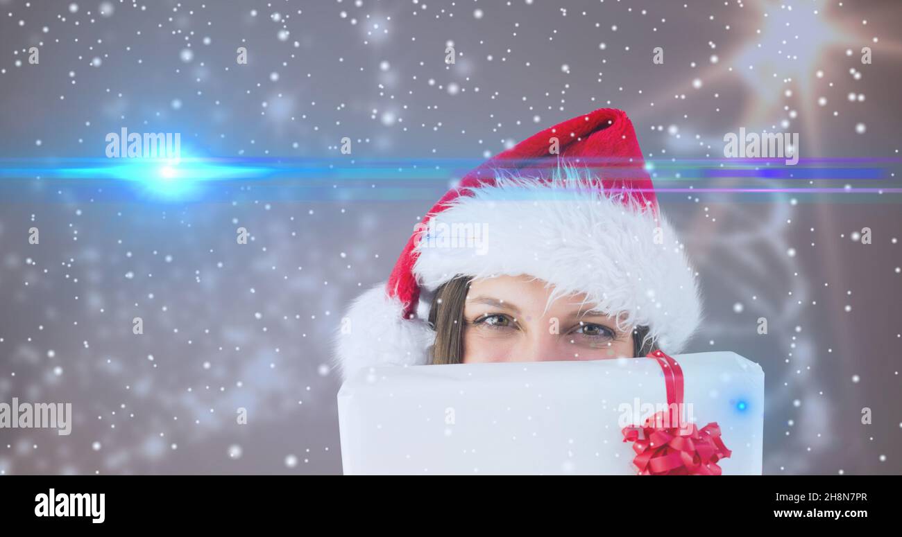 Immagine composita di donna con regalo di natale contro sfondo nevicante con spazio copia Foto Stock