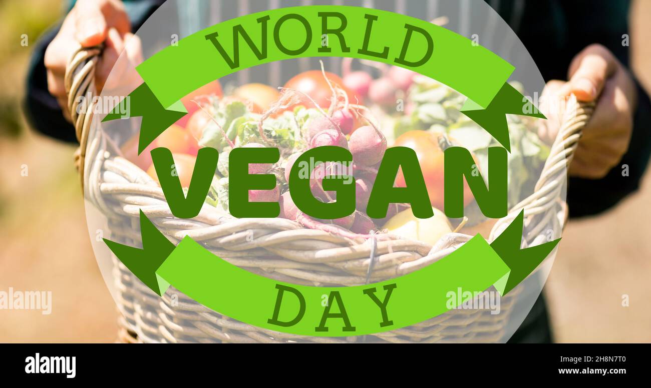 Simbolo del giorno vegano mondiale contro l'uomo che tiene un cesto pieno di verdure Foto Stock