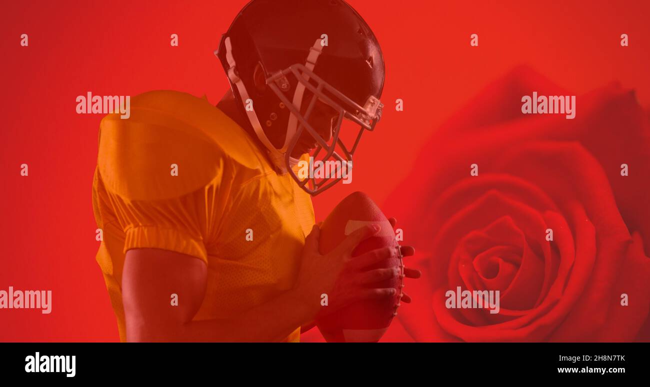 Vista laterale dell'atleta che tiene la palla del calcio americano su sfondo rosso rosa Foto Stock