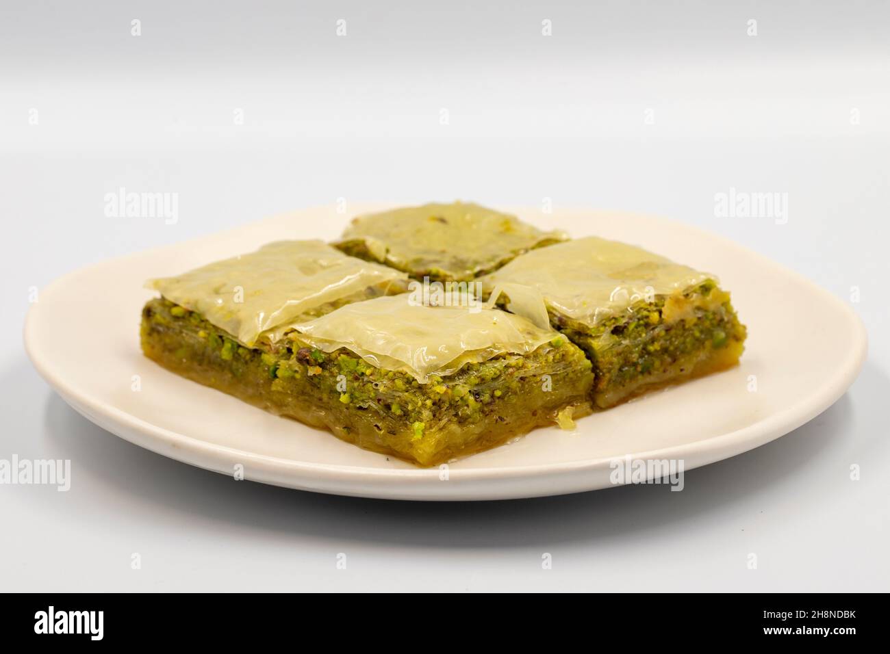 Pistacchio baklava su sfondo bianco. Presentazione e servizio di pistacchio baklava in stile turco. Vista orizzontale. Primo piano Foto Stock