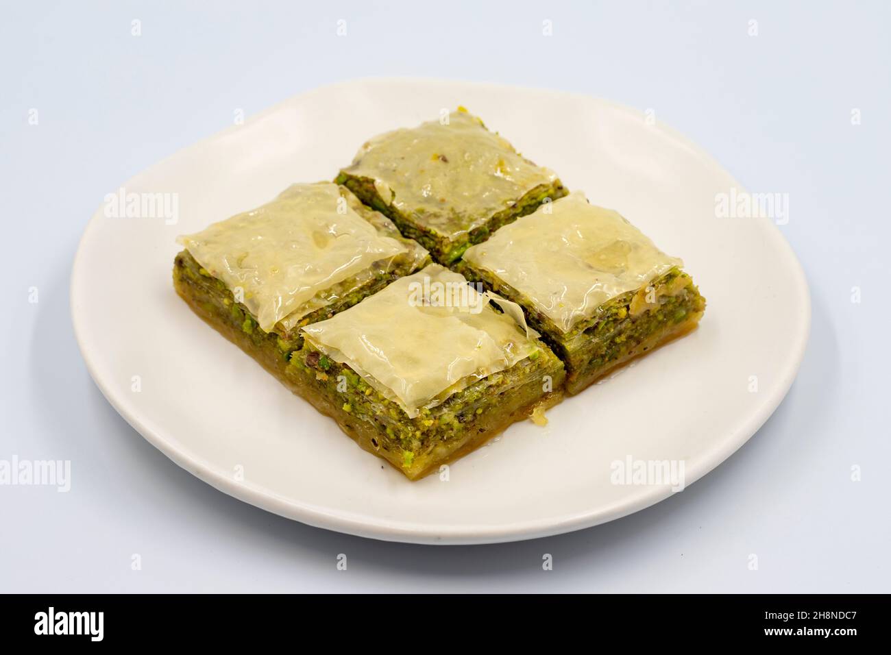 Pistacchio baklava su sfondo bianco. Presentazione e servizio di pistacchio baklava in stile turco. Vista orizzontale. Primo piano Foto Stock