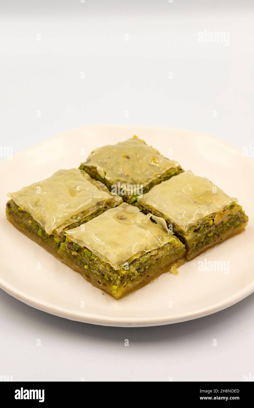 Pistacchio baklava su sfondo bianco. Presentazione e servizio di pistacchio baklava in stile turco. Vista verticale. Primo piano Foto Stock