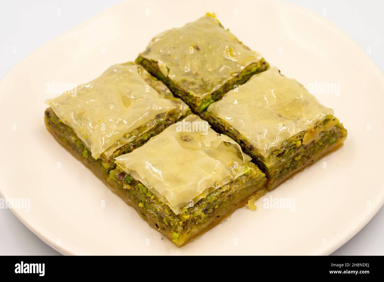 Pistacchio baklava su sfondo bianco. Presentazione e servizio di pistacchio baklava in stile turco. Vista orizzontale. Primo piano Foto Stock