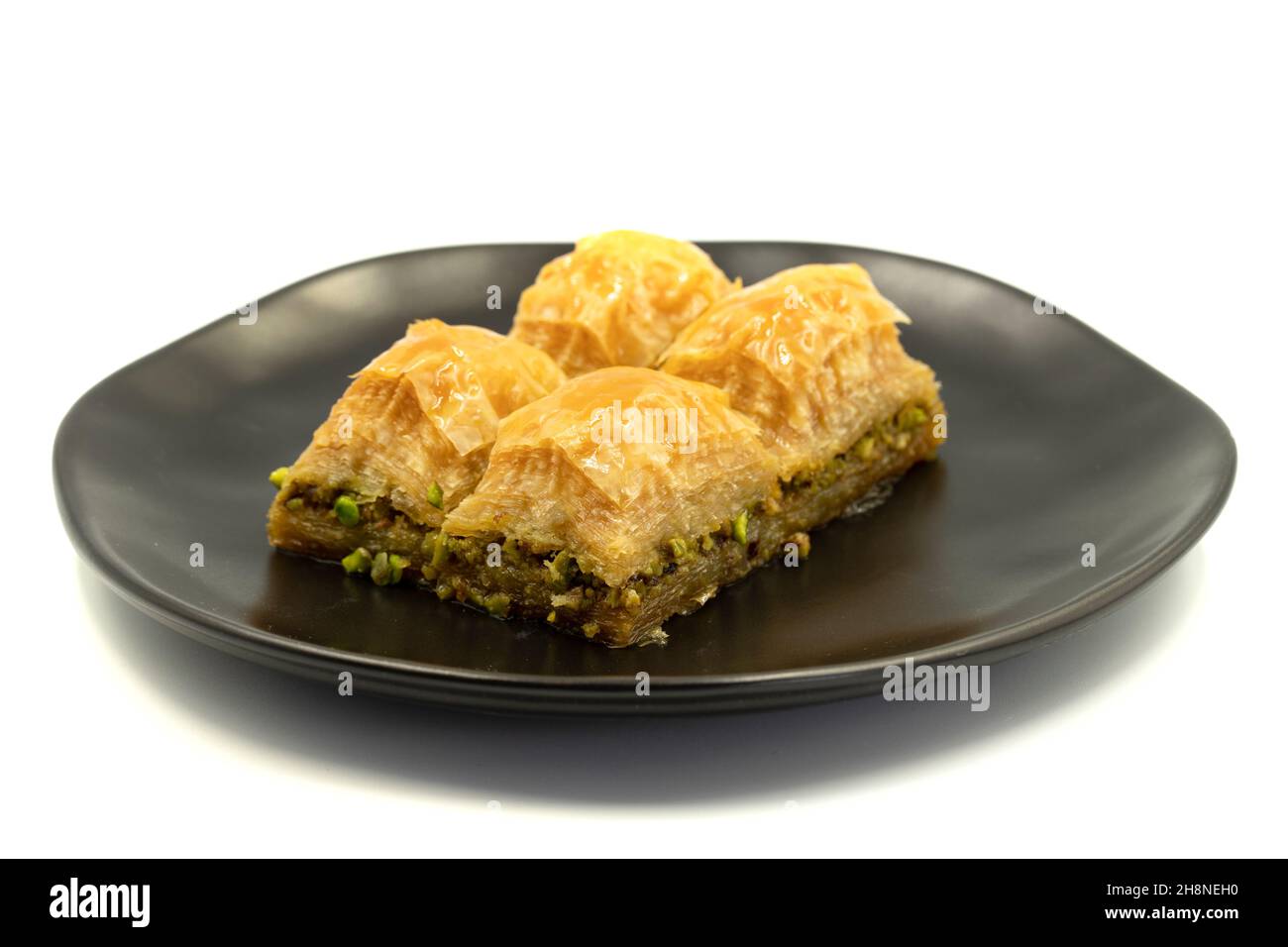 Pistacchio baklava isolato su sfondo bianco. Presentazione e servizio di pistacchio baklava in stile turco. Vista orizzontale. Primo piano Foto Stock