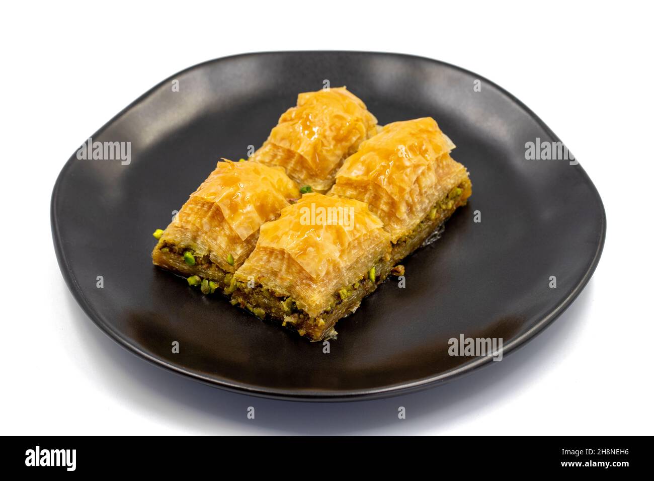 Pistacchio baklava isolato su sfondo bianco. Presentazione e servizio di pistacchio baklava in stile turco. Vista orizzontale. Primo piano Foto Stock