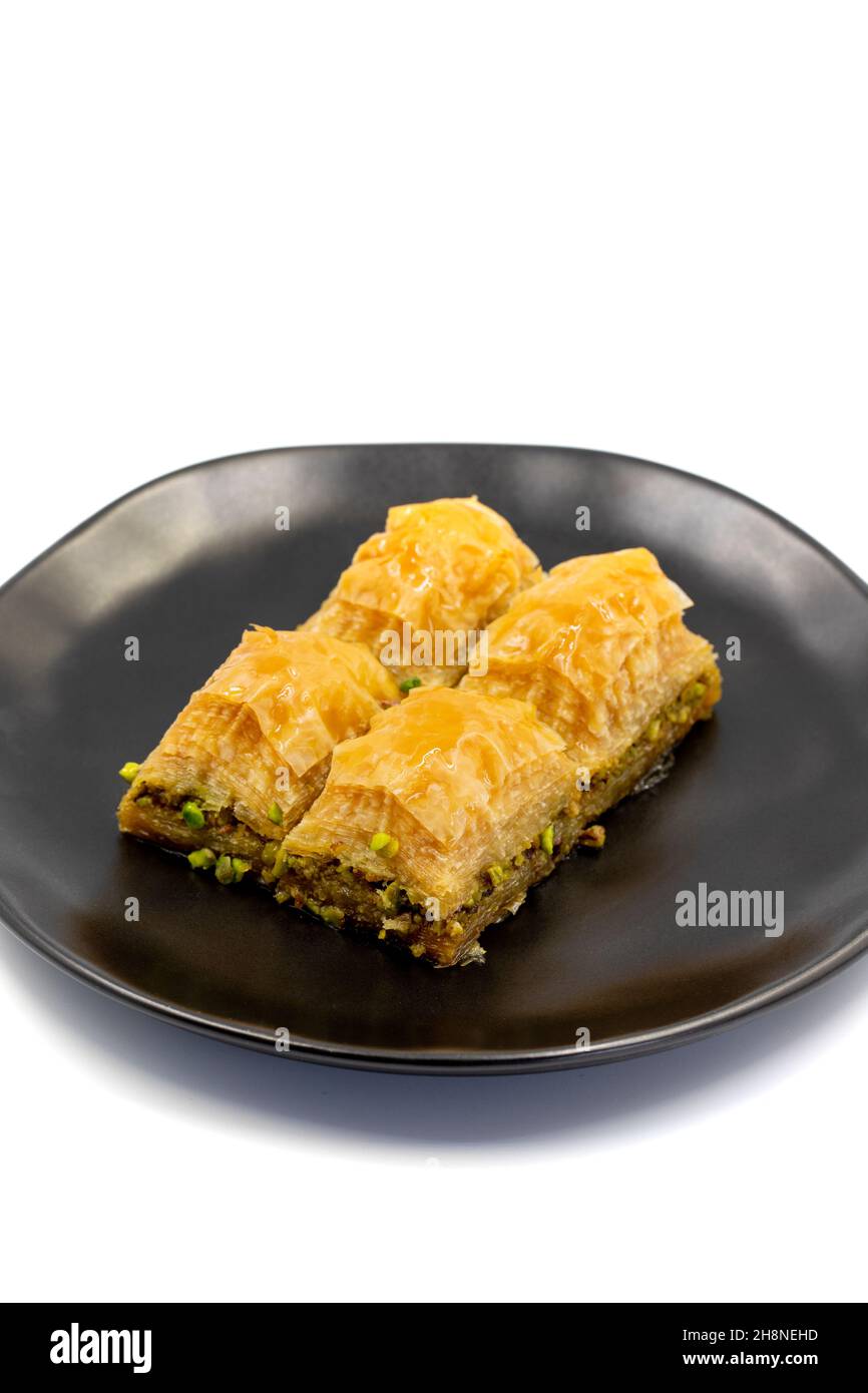 Pistacchio baklava isolato su sfondo bianco. Presentazione e servizio di pistacchio baklava in stile turco. Vista verticale. Primo piano Foto Stock