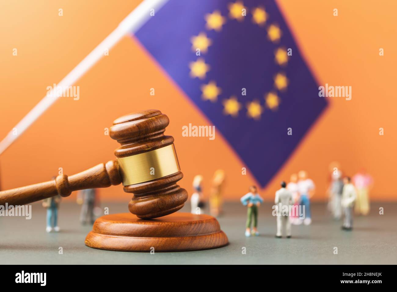 Giudice Gavel, bandiera dell'Unione europea e giocattoli di plastica su sfondo colorato, il concetto di contenzioso nella società europea Foto Stock