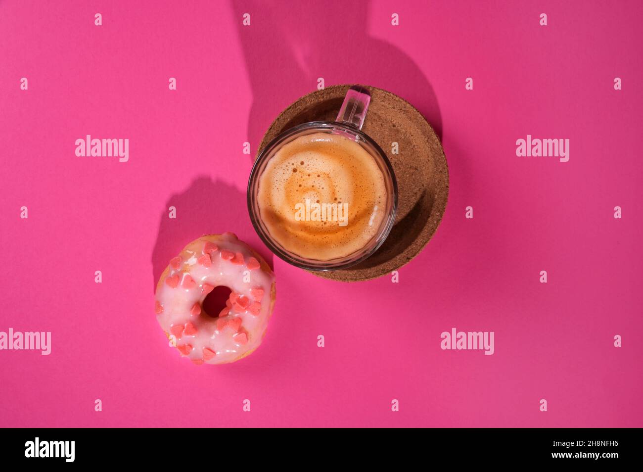 Il concetto di amore per le ciambelle caffè espresso. Ciambelle colorate creative su sfondo rosa pastello. Concetto minimo di cibo. Spazio di copia Foto Stock