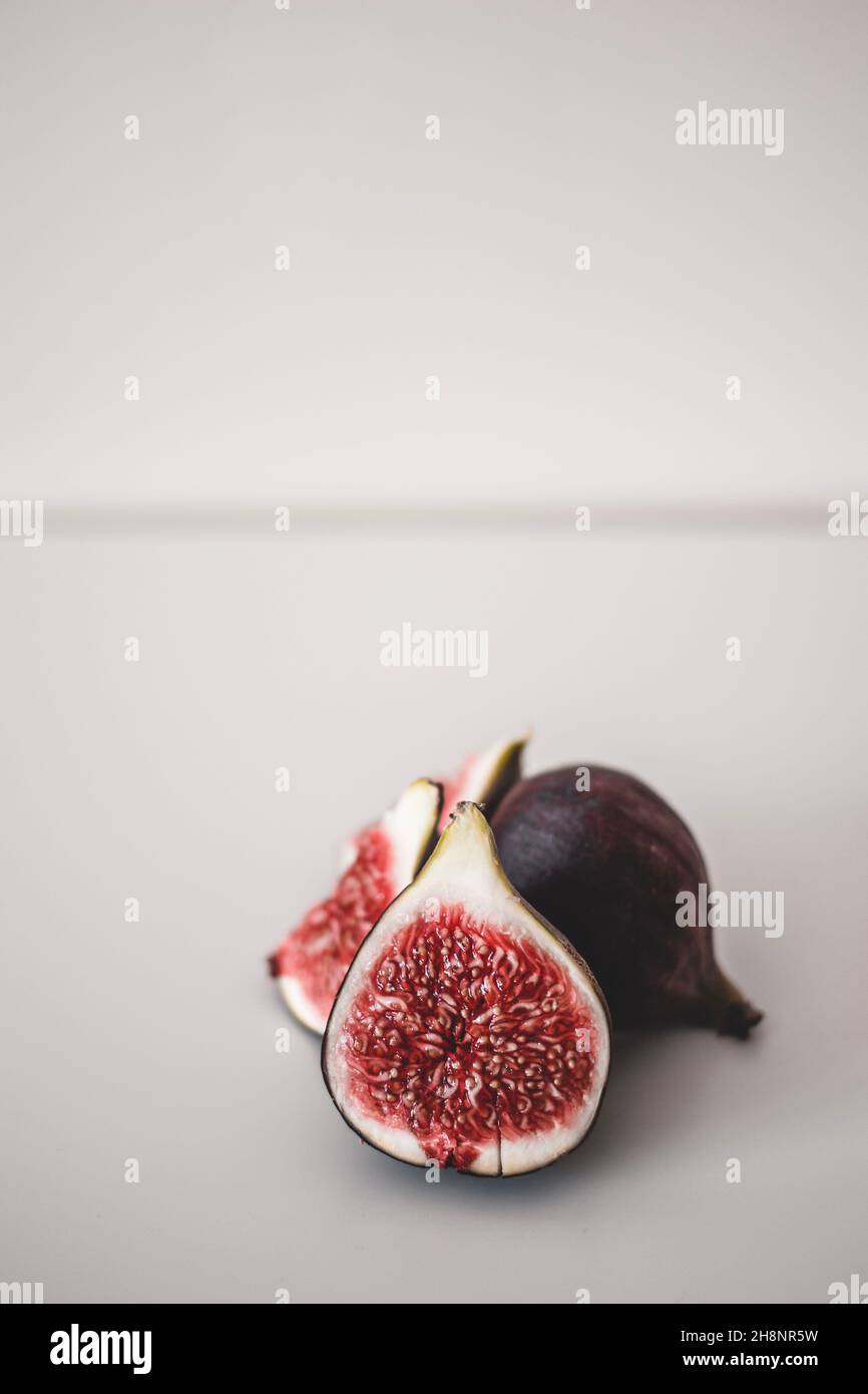 Succosa minimalismo fichi su sfondo chiaro. Polpa di fette di fico primo piano Foto Stock