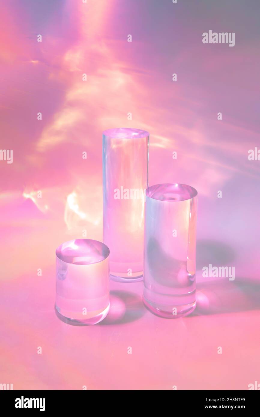 tre podi in vetro chiaro su sfondo rosa pastello Foto Stock