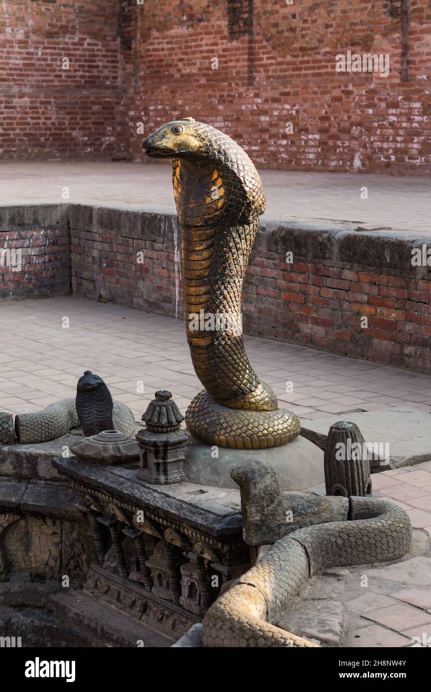 Un Naga di bronzo nel bagno reale di Naga Pokhari in Piazza Durbar nella città medievale di Newar di Bhaktapur, Nepal. La Naga è una creatura semi-divina in H. Foto Stock