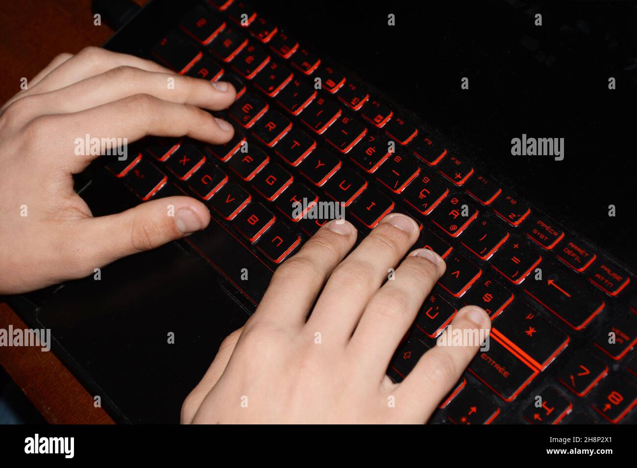 mani di un ragazzo joung su una tastiera del computer Foto Stock